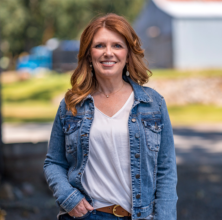 Christine Drazan standing on a farm smiling at the camera